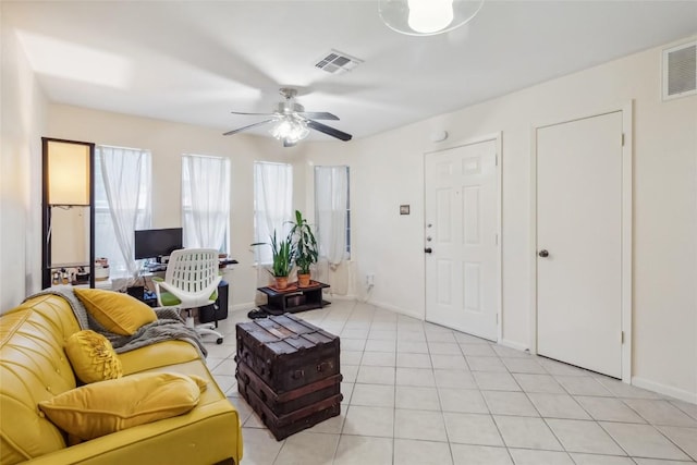 living room with light tile patterned floors, visible vents, and baseboards