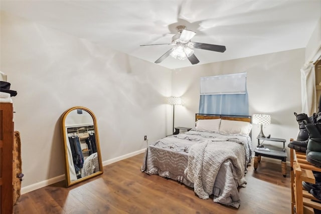 bedroom with a ceiling fan, baseboards, and wood finished floors