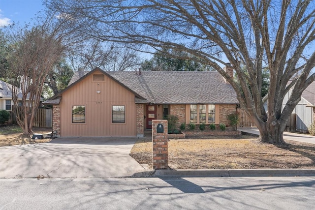 view of front of property with a chimney, fence, and concrete driveway