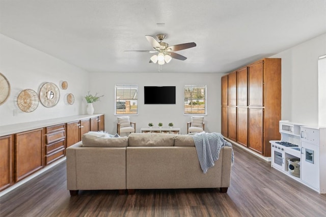 living area with dark wood-style flooring and a ceiling fan