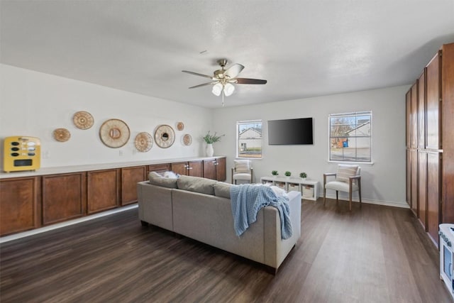 living room featuring dark wood finished floors, a ceiling fan, and baseboards