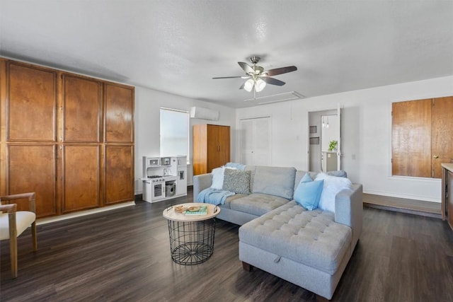 living area featuring attic access, an AC wall unit, baseboards, and dark wood-style flooring