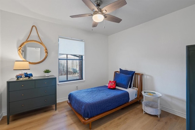 bedroom with light wood finished floors, a ceiling fan, and baseboards