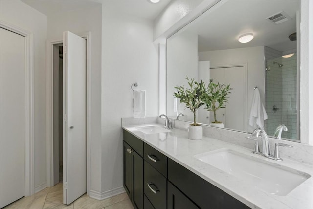 bathroom featuring double vanity, a sink, visible vents, and a shower stall