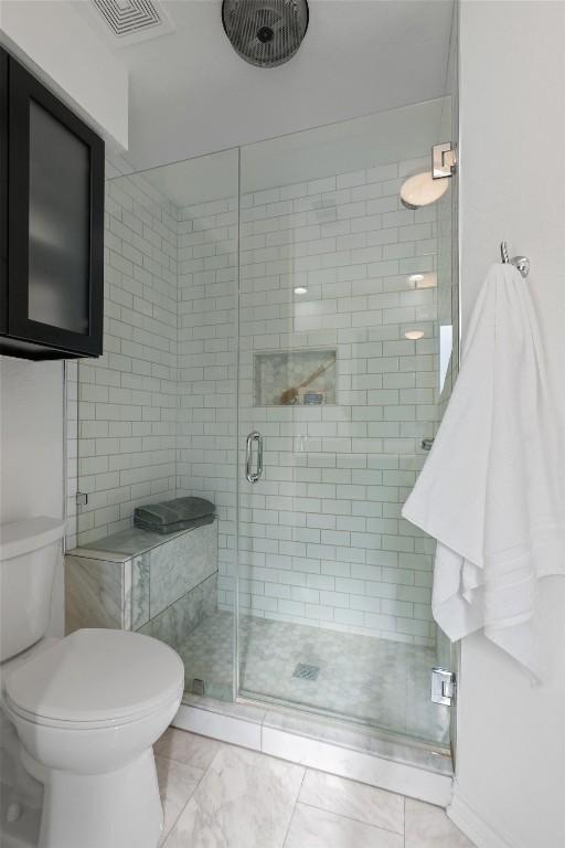 full bathroom featuring visible vents, a shower stall, and toilet