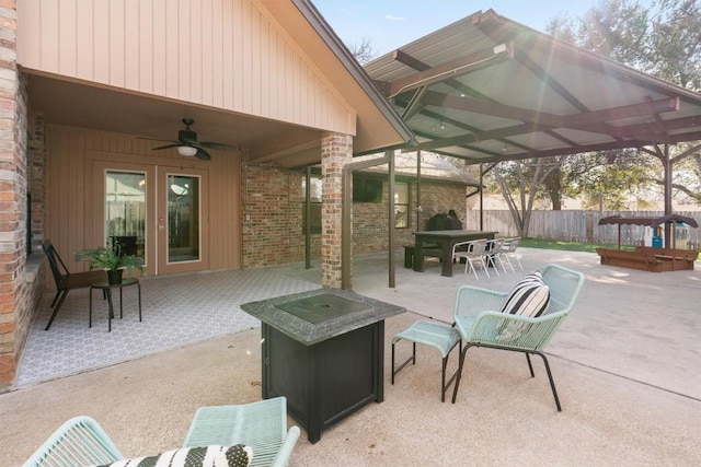 view of patio / terrace featuring a fire pit, ceiling fan, fence, and french doors