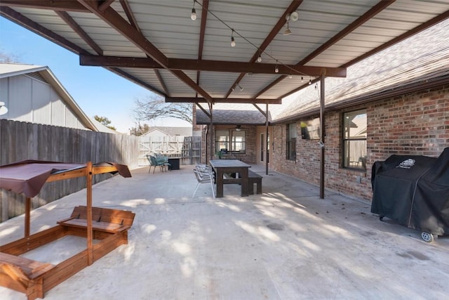 view of patio featuring outdoor dining area, a grill, and fence