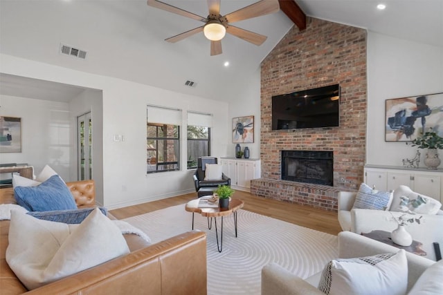 living room featuring visible vents, beamed ceiling, a fireplace, and wood finished floors