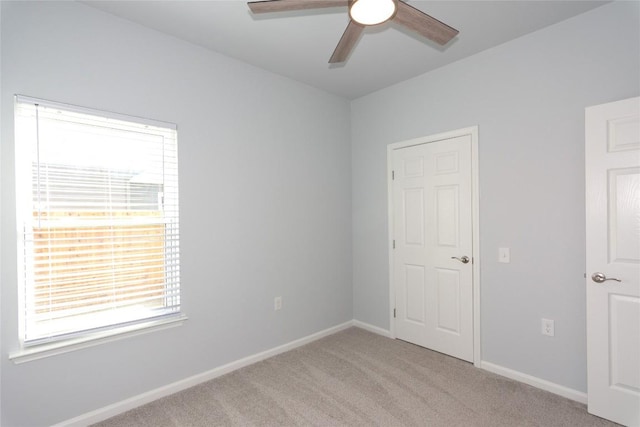 unfurnished bedroom featuring light carpet, ceiling fan, and baseboards