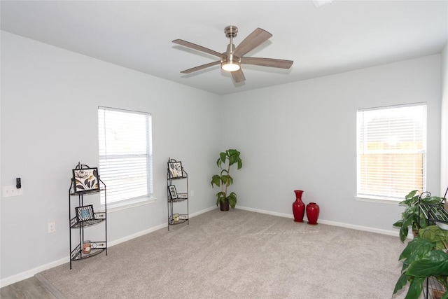 miscellaneous room with ceiling fan, light colored carpet, a wealth of natural light, and baseboards