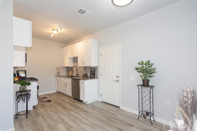 kitchen featuring stainless steel dishwasher, light wood-type flooring, white cabinetry, and decorative backsplash