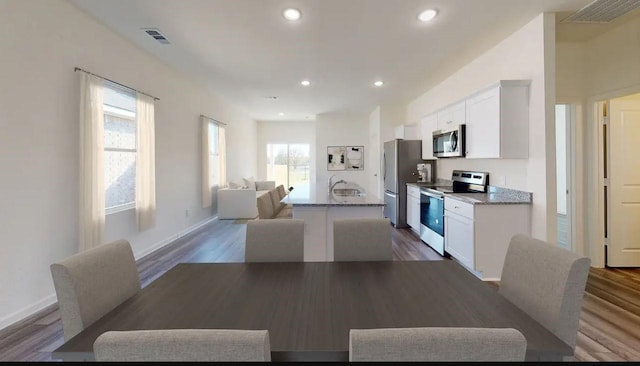 dining room featuring dark wood-type flooring, visible vents, and recessed lighting