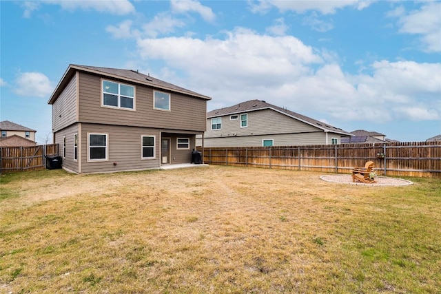 rear view of house featuring a fire pit, a yard, a patio area, and a fenced backyard