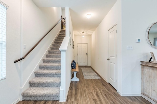 stairway with wood finished floors and baseboards