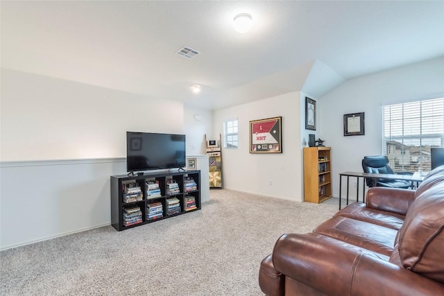 living area with carpet, visible vents, and vaulted ceiling