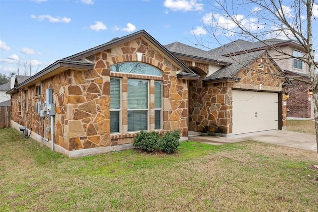 view of front of house with an attached garage, a shingled roof, stone siding, concrete driveway, and a front yard