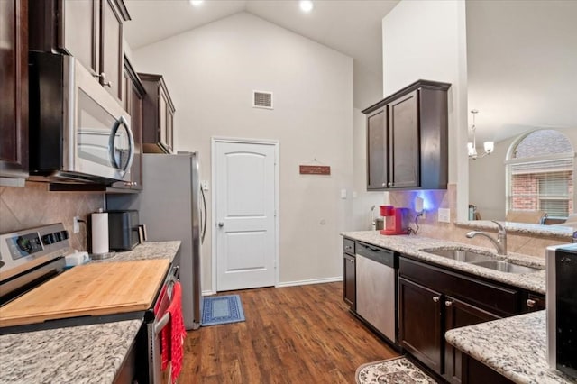 kitchen with stainless steel appliances, visible vents, a sink, and dark brown cabinets