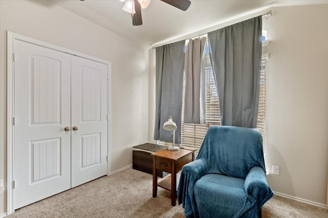 living area with baseboards, a ceiling fan, and carpet flooring