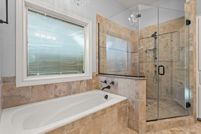 bathroom with a wealth of natural light, a garden tub, and a shower stall