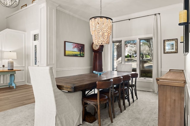 dining room featuring ornamental molding, a notable chandelier, and light wood-style flooring