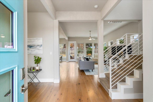 foyer with a ceiling fan, visible vents, baseboards, beam ceiling, and hardwood / wood-style flooring