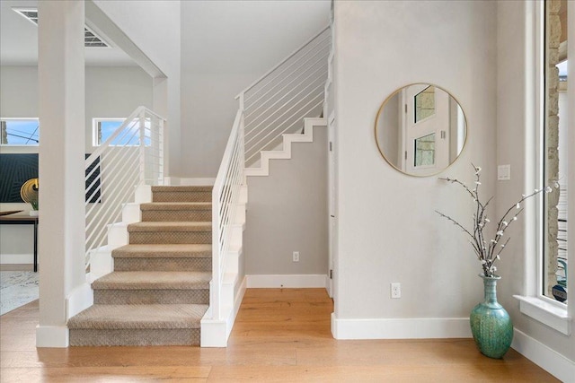 stairway with baseboards and wood finished floors