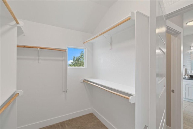 walk in closet featuring vaulted ceiling