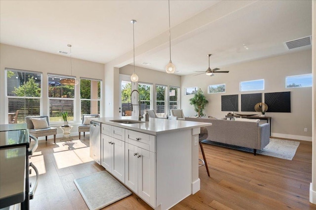 3011 Chisholm Trl, Austin, TX 78734 - kitchen with wood finished floors, white cabinets, decorative light fixtures, ceiling fan, and open floor plan