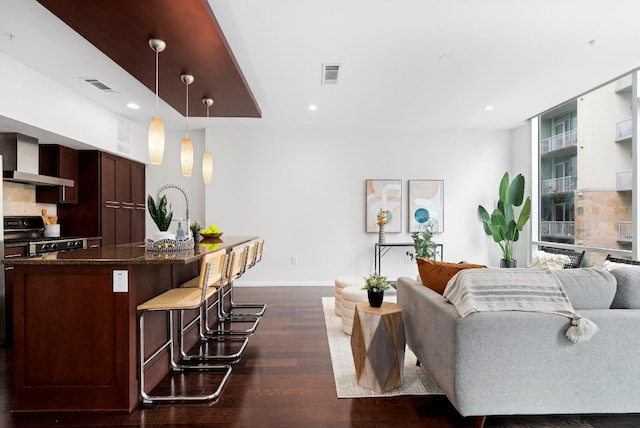 living room featuring baseboards, visible vents, dark wood-style flooring, and recessed lighting