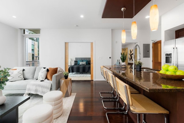 living area featuring recessed lighting, electric panel, and dark wood finished floors