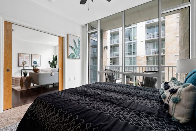bedroom with expansive windows and wood finished floors