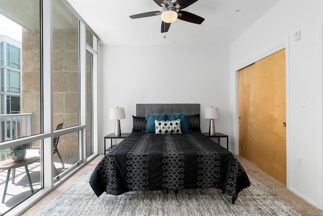 carpeted bedroom with expansive windows, ceiling fan, and multiple windows