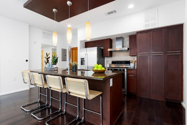 kitchen featuring visible vents, a kitchen island, stainless steel fridge with ice dispenser, stove, and wall chimney range hood
