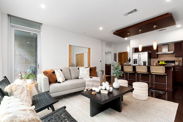 living area with wood finished floors, visible vents, and recessed lighting