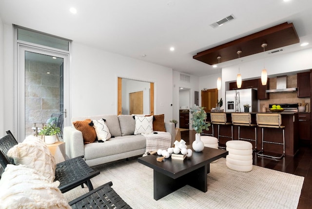 living room with visible vents, recessed lighting, and wood finished floors