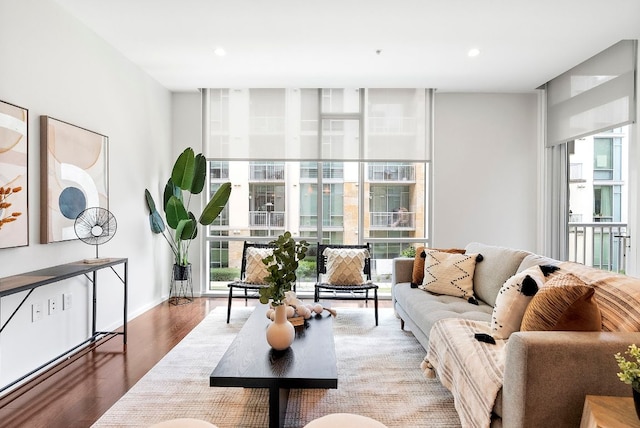 living room featuring expansive windows, baseboards, recessed lighting, and wood finished floors