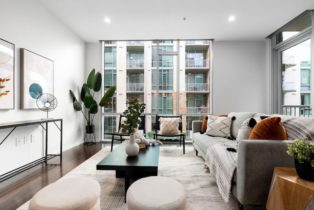 interior space with baseboards, a wall of windows, wood finished floors, and recessed lighting