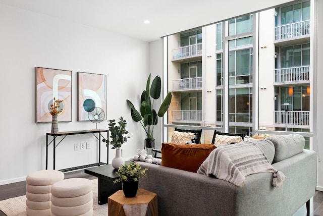 sitting room featuring expansive windows, baseboards, wood finished floors, and recessed lighting