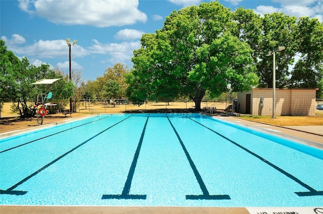 pool with an outbuilding and fence