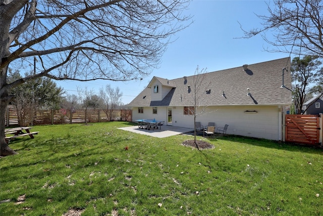 rear view of house with a patio area, fence, and a yard