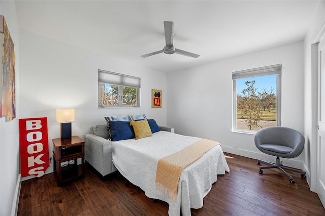 bedroom with ceiling fan, dark wood-type flooring, multiple windows, and baseboards