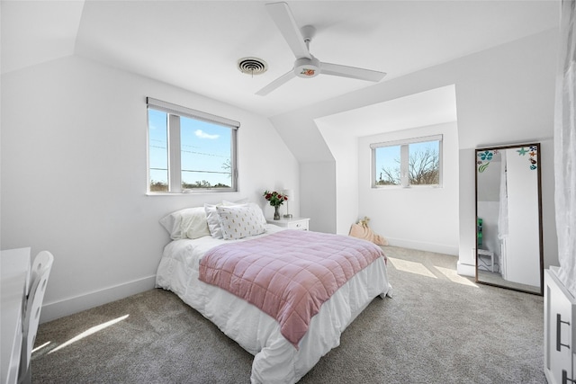 bedroom with visible vents, vaulted ceiling, carpet flooring, and multiple windows