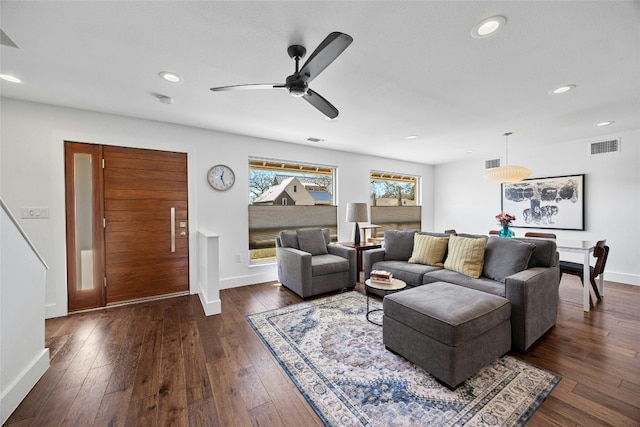 living area with baseboards, visible vents, dark wood finished floors, and recessed lighting