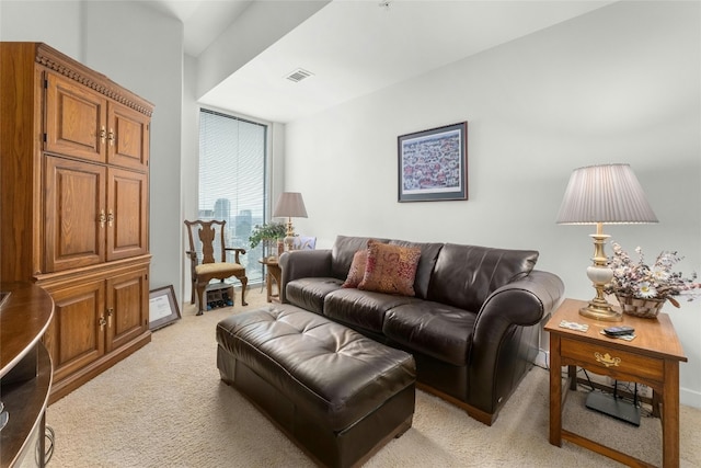 living room featuring expansive windows, visible vents, and light colored carpet