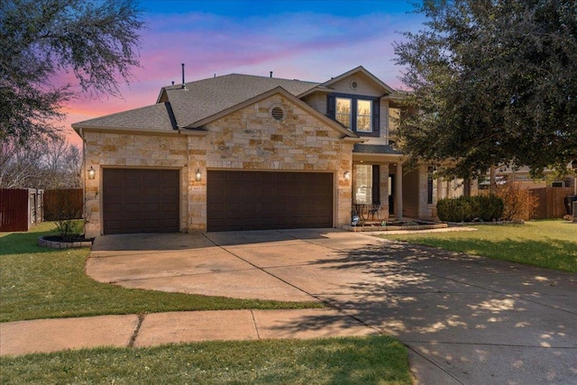 view of front of home featuring a garage, stone siding, and fence