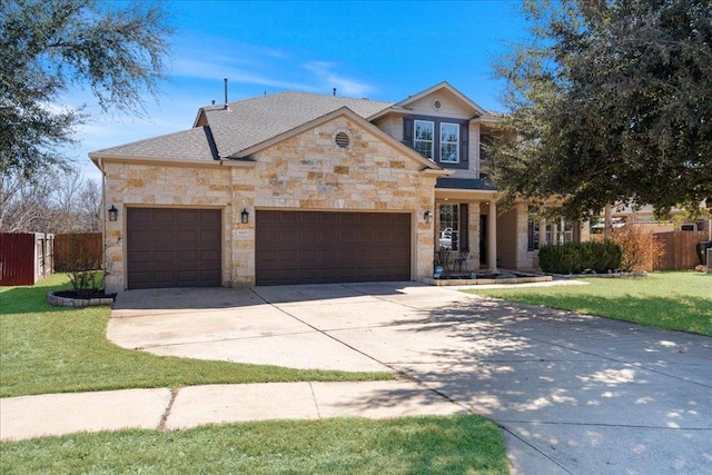 traditional-style house with a garage, stone siding, fence, and driveway