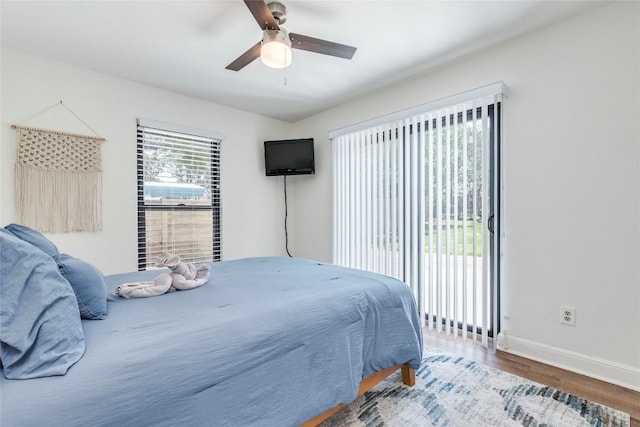 bedroom featuring access to outside, baseboards, ceiling fan, and wood finished floors