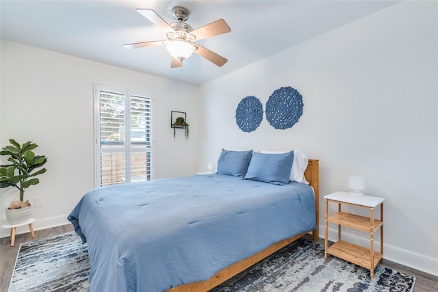 bedroom with ceiling fan, baseboards, and wood finished floors