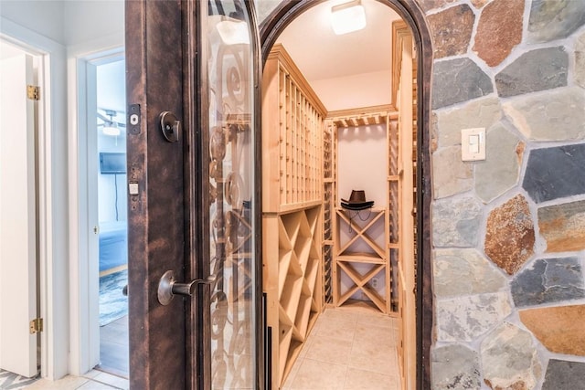 wine room featuring arched walkways and light tile patterned flooring