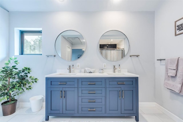 bathroom with double vanity, tile patterned flooring, a sink, and baseboards